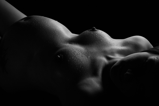 liegende schwangere frau auf schwarz-weiss photo vom fotograf münchen